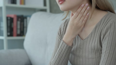 亚洲女性因喉咙疼痛而将手放在她的脖子上女性扁桃体炎