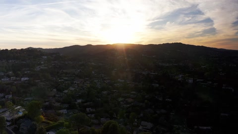 向着日落方向飞越丘陵的空中拍摄视频素材模板下载