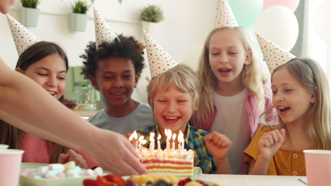 孩子们在蛋糕上吹蜡烛视频素材模板下载