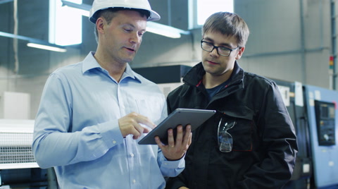 安全帽工程师和工厂工人正在使用平板电脑视频素材模板下载