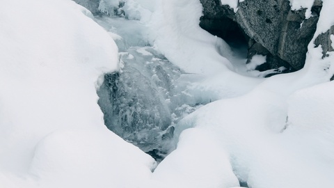 水在冰冻的小溪下流动 