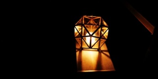 露营时黑暗中火焰闪烁的几何烛台