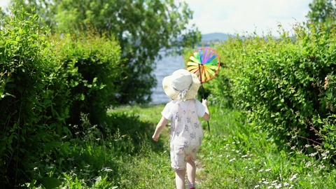 小女孩在花园里玩彩色风车