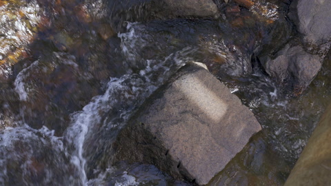 河水在河岸上的一些旧碎石头周围奔流视频素材模板下载