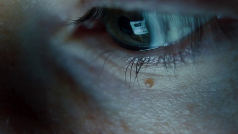 一名男子眼睛接近手机屏幕，在深色的晚间浏览网站，4K 拍摄