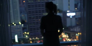 晚上看城市的女人影子，站在家里的窗户旁