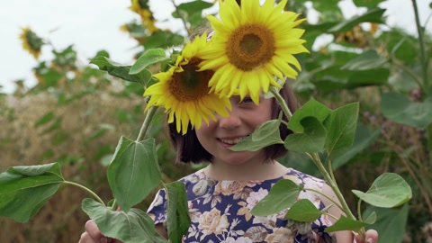 漂亮的女孩用向日葵遮住了她的眼睛视频素材模板下载