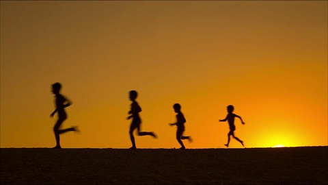 夕阳下五个奔跑的孩子的剪影