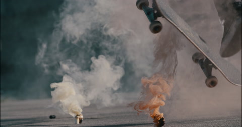 滑板运动员跳过彩色烟雾