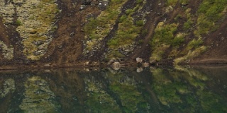冰岛克雷奥陨击坑蓝水中火山石的惊人水倒影