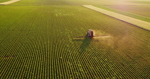 无人机拍摄的一个农民喷洒大豆田的照片