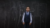 4K小男孩站在黑板前画建筑物高清在线视频素材下载