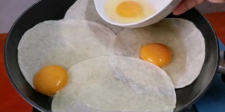 将新鲜鸡蛋倒在玉米饼卷或油炸玉米饼上