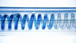 科学实验室冷凝器蓝色液体的水平流动螺旋。视频素材模板下载