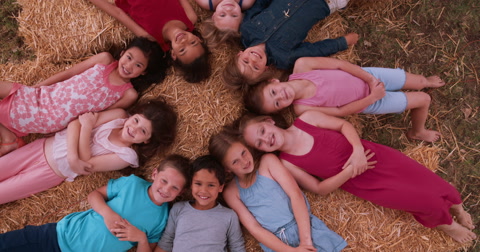 多民族儿童围成一圈躺在稻草上