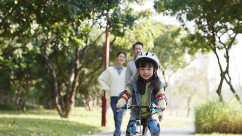 亚洲小女孩骑自行车户外在公园