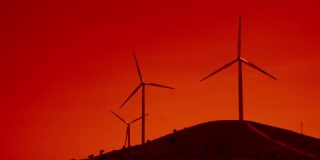 风力涡轮机在乡村山区景观中旋转，红色天空效应