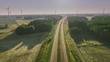 日出时高速公路附近风力涡轮机的鸟瞰图高清在线视频素材下载