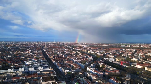 阳光和雨水在柏林上空形成彩虹戏剧性的空中俯视图飞行无人机视频素材模板下载