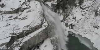 4K拍摄的覆盖着雪的森林中的小瀑布