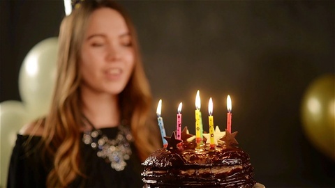 快乐的情感女孩在庆祝生日和掌声时吹灭蜡烛视频素材模板下载