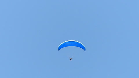 滑翔伞飞行在清澈的蓝天中