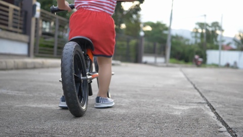 儿童在街上骑平衡自行车慢动作视频素材模板下载
