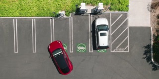 4K空中俯视图红色电动汽车停放在室外充电站