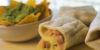 热的新鲜墨西哥卷饼和墨西哥玉米片与鳄梨色拉酱奶油的特写。
