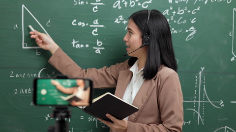 年轻的亚洲女教师站在摄像机直播讲课视频素材模板下载