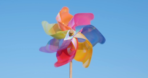 一个旋转的塑料风车吹着风站在海边的沙滩上