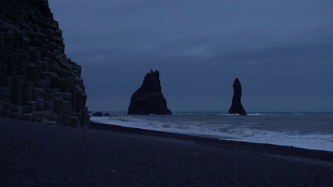 诡异而神秘的海蚀柱，在黑色沙滩上的夜晚
