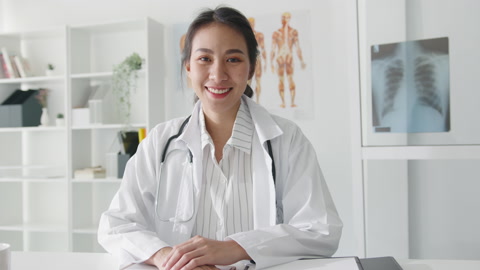 年轻的亚洲女医生在保健医院看着镜头微笑。