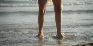日落时分，女人在海水上跳舞的腿特写