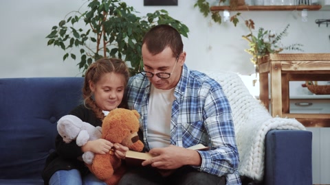 爸爸在家给女儿读了一本书。孩子梦想冠状病毒呆在家里视频素材模板下载
