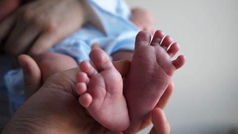 当母亲把婴儿抱在手上时，婴儿的腿和脚才三个星期视频素材模板下载