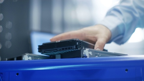 在完全工作的数据中心，IT工程师将硬盘安装到服务器机架中。 