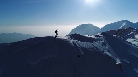 男人在雪山顶上徒步旅行航拍