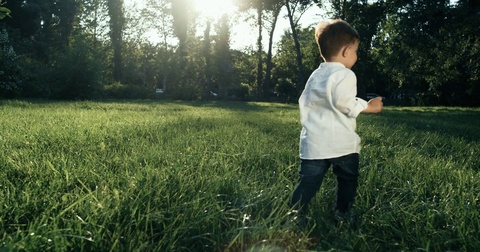 穿着白衬衫在草地上奔跑的男孩