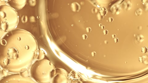 在1000fps下以超慢动作拍摄了在金色背景上移动的油泡