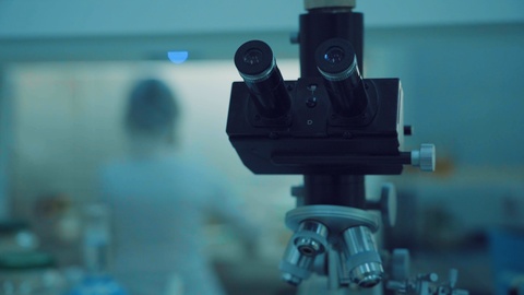 女科学家显微镜研究。看起来像女科学家的显微镜。实验室视频素材模板下载