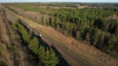 从森林看铁路上的客运列车，鸟瞰图。带客车的火车视频素材模板下载