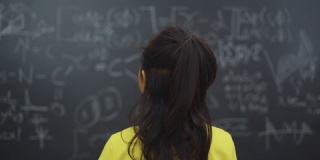 一个女人正在研究黑板上的问题