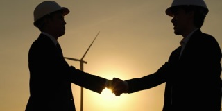 商人们正在握手，代表对风力涡轮机的联合投资