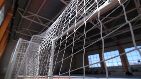 体育学校体育馆窗户旁边带网孔的足球门