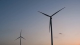 风力发电机在日落时分的蓝天下映衬出轮廓，洁净无污染高清在线视频素材下载