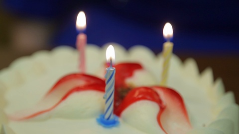 一个人吹灭节日蛋糕上燃烧的蜡烛。视频素材模板下载