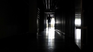 一个人在黑暗的走廊里奔跑。视频素材模板下载