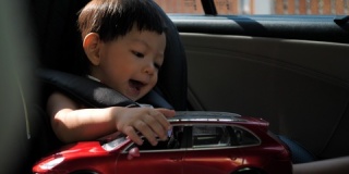 可爱的婴儿在汽车座椅上玩玩具
