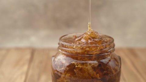 玻璃碗里的液态有机蜂蜜和蜂巢特写金色新鲜的蜂蜜视频素材模板下载